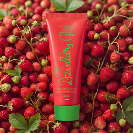 Dzintars Asari Wild Strawberry Gel Toothpaste tube on a bed of fresh wild strawberries – advanced whitening with fluoride 1450 ppm F